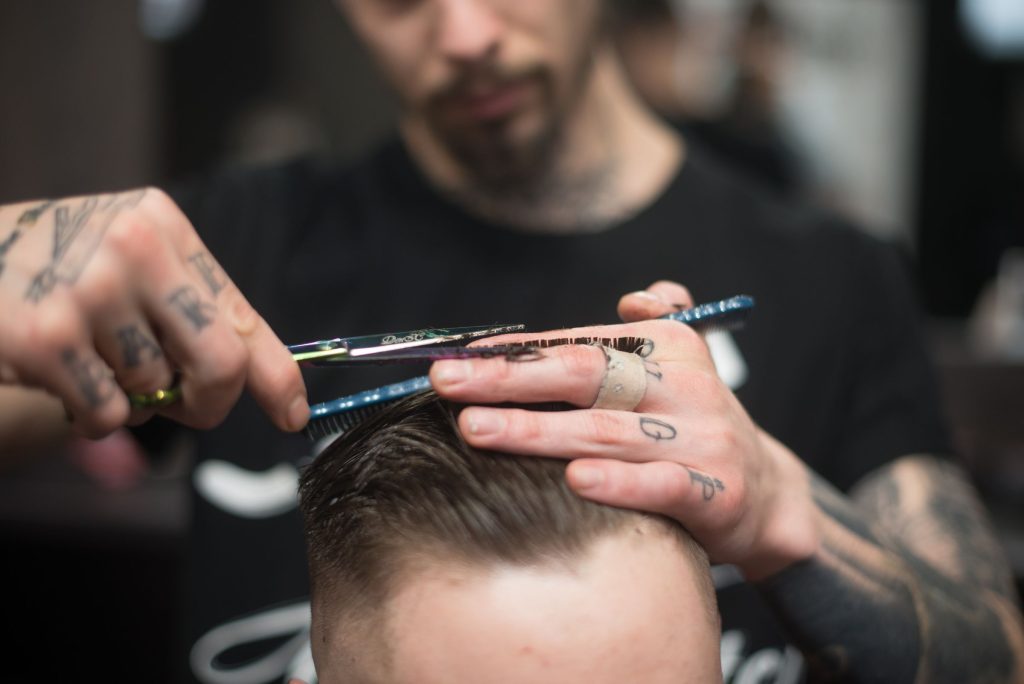 Barbier schneidet Herrenhaare mit der Schere